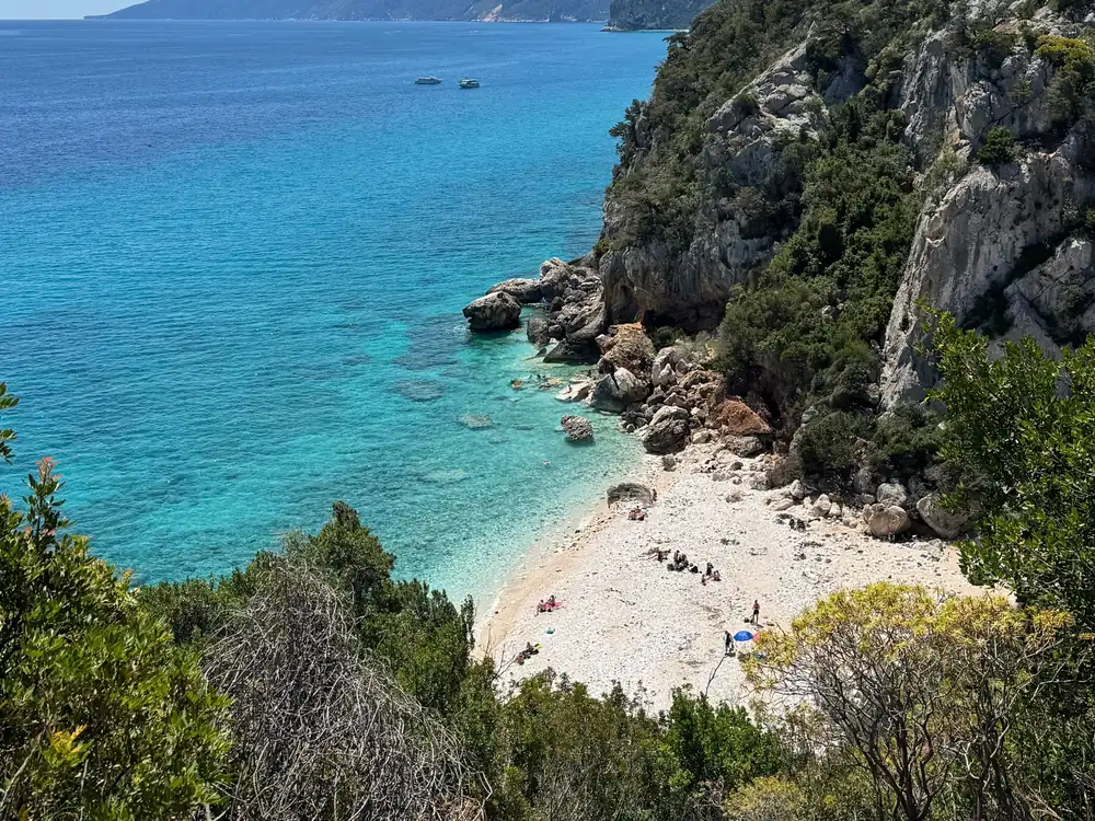 Utsikt fra stien ned mot den hvite steinstranden og det turkise vannet ved Cala Goloritzé