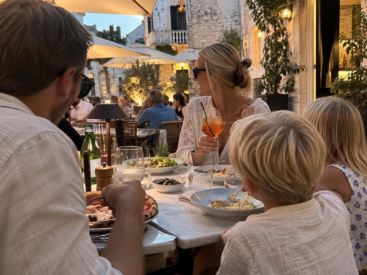Familie som spiser middag på en uteservering en sommerkveld